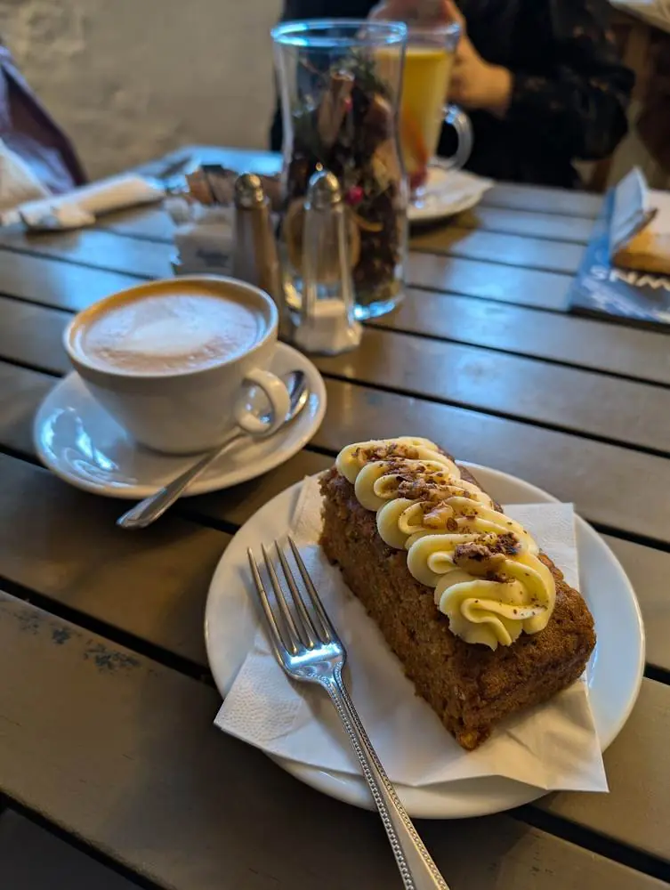 A plated slice of carrot cake served with coffee